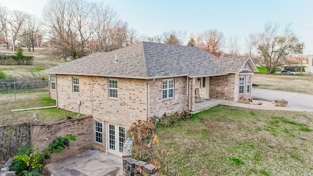 view of side of home with a lawn and a patio