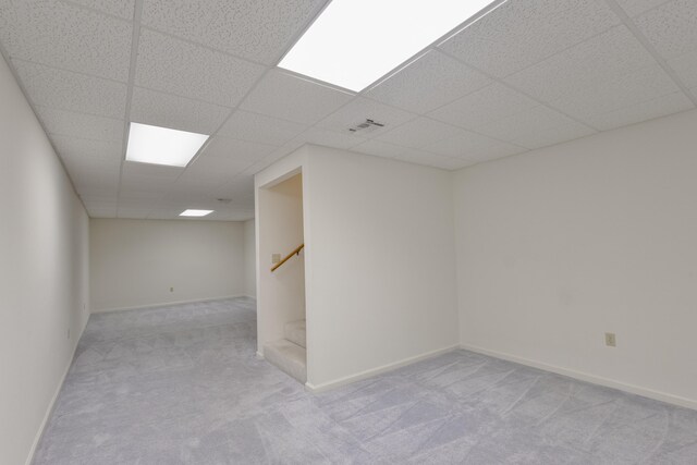 spare room with light carpet and a drop ceiling