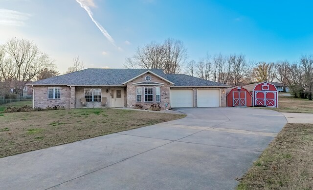 ranch-style house featuring a front lawn and a shed