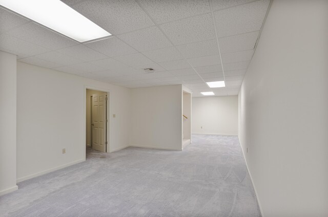 unfurnished room with light colored carpet and a drop ceiling