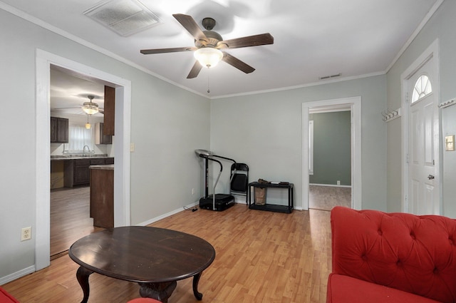 interior space with a healthy amount of sunlight, light hardwood / wood-style flooring, ceiling fan, and ornamental molding