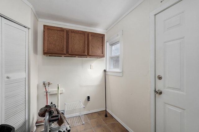 laundry room with cabinets, light tile patterned floors, and crown molding