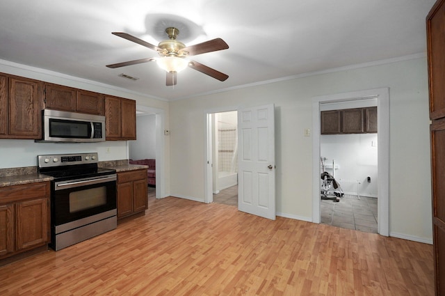 kitchen with ceiling fan, stainless steel appliances, light wood-type flooring, dark countertops, and crown molding