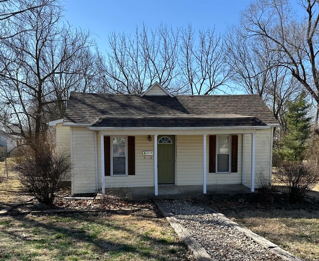 bungalow-style home featuring a shingled roof and covered porch