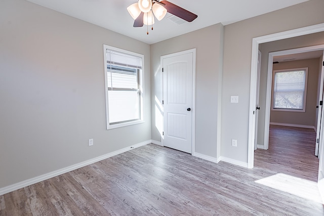 unfurnished bedroom featuring light hardwood / wood-style flooring, multiple windows, and ceiling fan