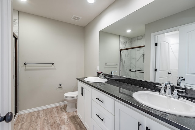 bathroom with vanity, toilet, an enclosed shower, and wood-type flooring