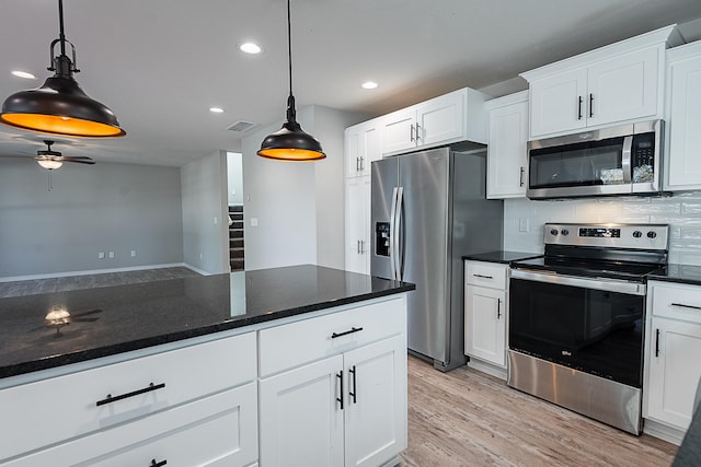 kitchen featuring white cabinetry, decorative light fixtures, decorative backsplash, appliances with stainless steel finishes, and light wood-type flooring