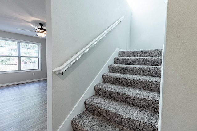 stairway with ceiling fan and hardwood / wood-style floors