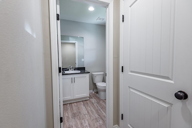 bathroom featuring vanity, hardwood / wood-style flooring, and toilet