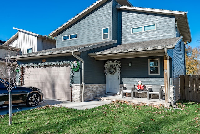 view of front of property with a porch, a garage, and a front lawn