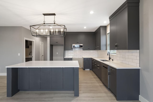 kitchen featuring pendant lighting, a center island, light hardwood / wood-style flooring, and sink