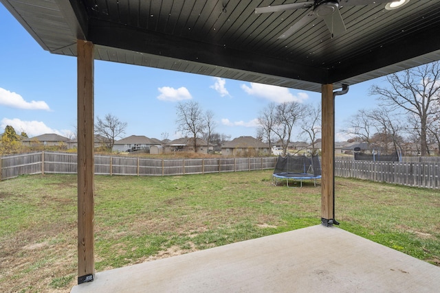 view of yard featuring ceiling fan, a patio area, and a trampoline