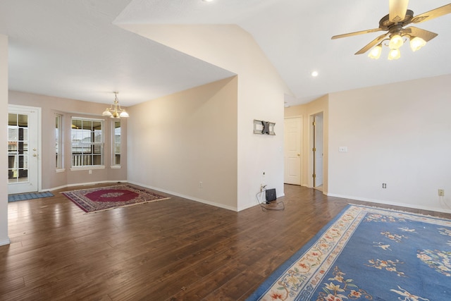 interior space with ceiling fan with notable chandelier, dark wood-type flooring, and lofted ceiling