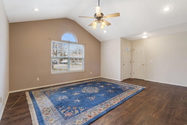 empty room featuring dark hardwood / wood-style floors, vaulted ceiling, and ceiling fan