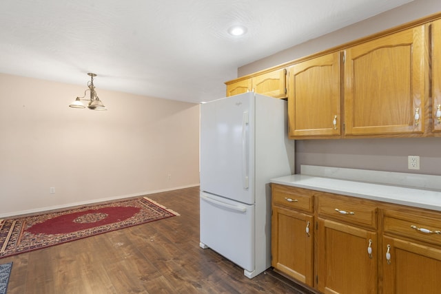 kitchen featuring pendant lighting, dark hardwood / wood-style flooring, and white fridge