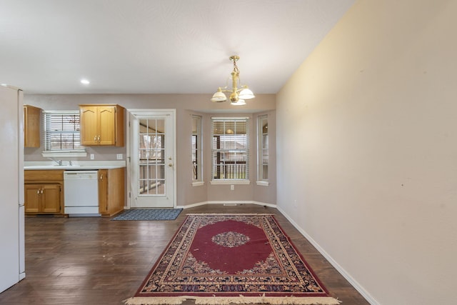 kitchen with dark hardwood / wood-style floors, decorative light fixtures, white appliances, and a notable chandelier