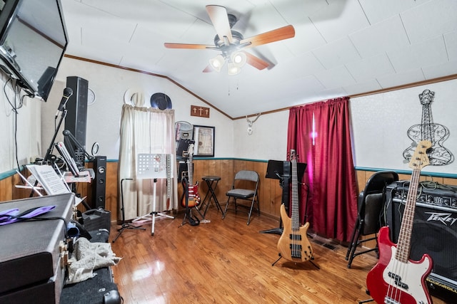 miscellaneous room with vaulted ceiling, ceiling fan, crown molding, hardwood / wood-style floors, and wood walls