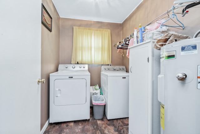 laundry area with independent washer and dryer, wooden walls, and water heater