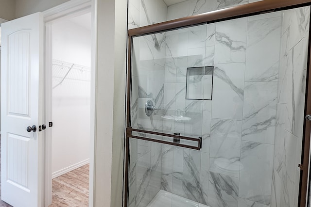 bathroom with wood-type flooring and a shower with door