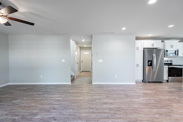 kitchen with white cabinets, appliances with stainless steel finishes, light hardwood / wood-style flooring, and ceiling fan