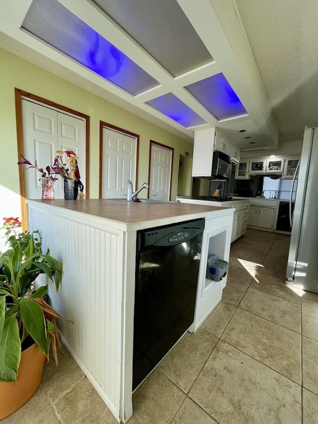 kitchen featuring black appliances, white cabinets, sink, light tile patterned floors, and kitchen peninsula