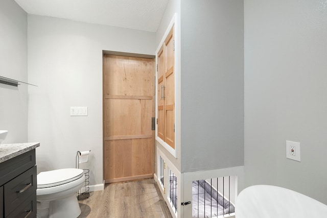 bathroom featuring hardwood / wood-style floors, vanity, a textured ceiling, and toilet