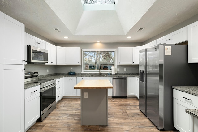 kitchen featuring a kitchen island, white cabinetry, and stainless steel appliances