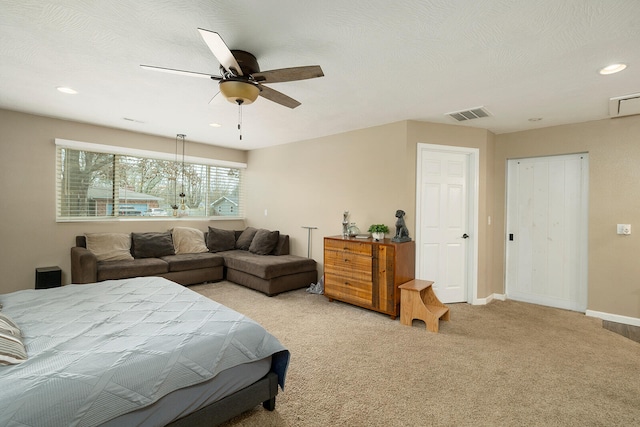 bedroom featuring ceiling fan, light carpet, and a textured ceiling