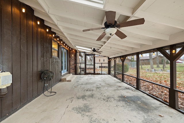 unfurnished sunroom featuring ceiling fan and lofted ceiling with beams