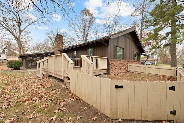 rear view of house with a deck and a sunroom