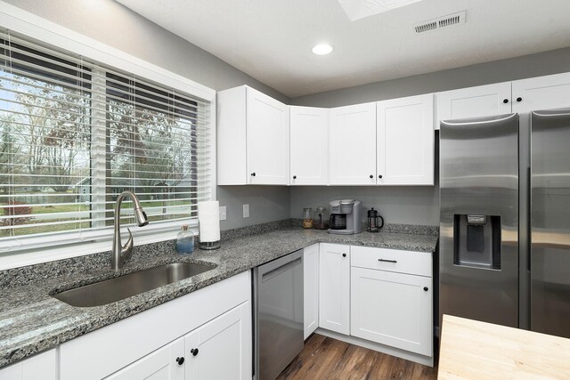 kitchen with white cabinets, sink, stainless steel appliances, and dark wood-type flooring