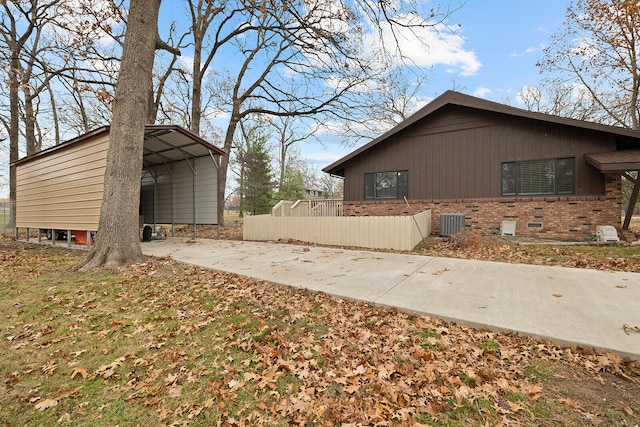 view of side of home with a carport and central air condition unit