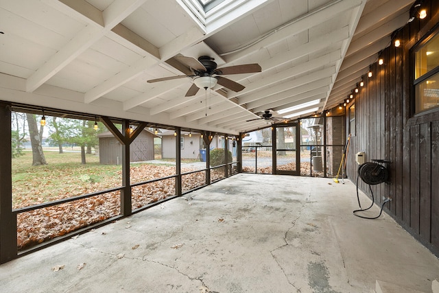 unfurnished sunroom featuring vaulted ceiling with beams and ceiling fan