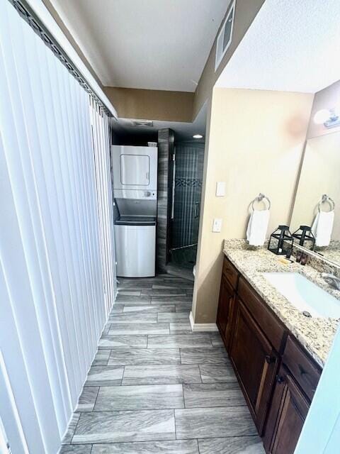 bathroom featuring vanity and stacked washing maching and dryer