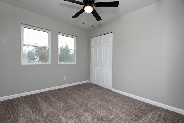 unfurnished bedroom featuring carpet, ceiling fan, a textured ceiling, and a closet