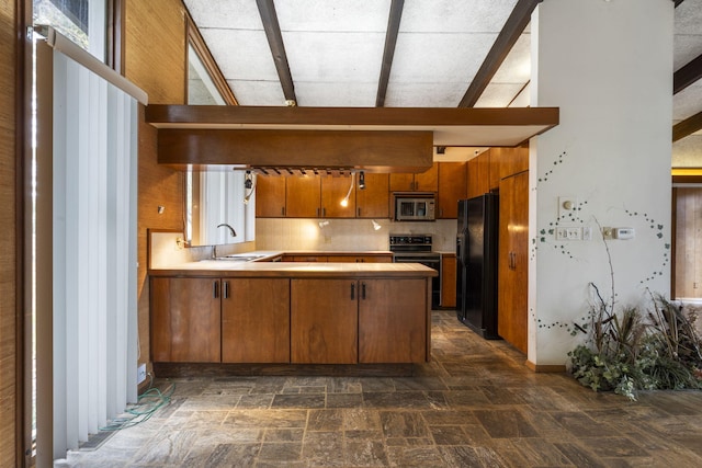 kitchen featuring kitchen peninsula, sink, backsplash, and black appliances