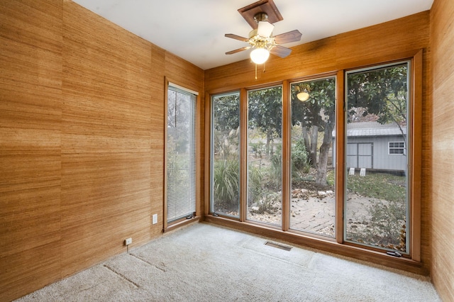 unfurnished sunroom featuring ceiling fan and a wealth of natural light