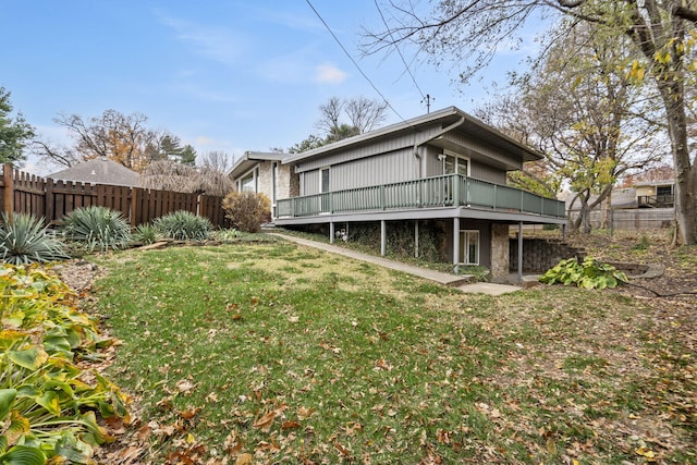 rear view of house featuring a yard and a wooden deck