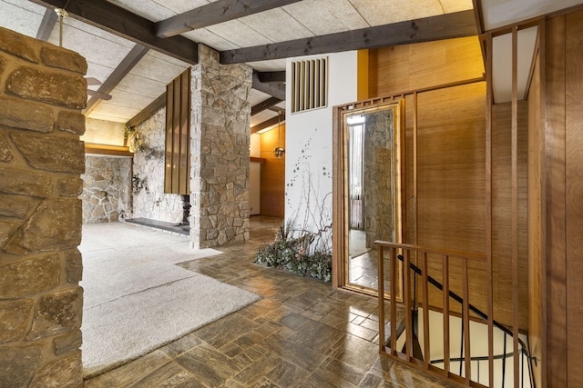 hall featuring beamed ceiling and high vaulted ceiling