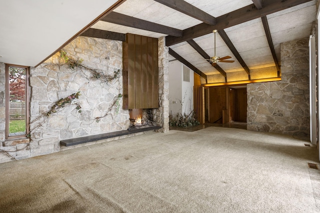 unfurnished living room featuring carpet flooring, vaulted ceiling with beams, ceiling fan, and a fireplace