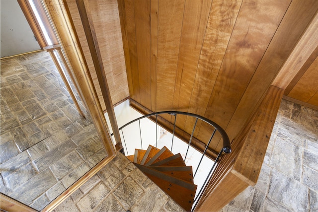 staircase featuring wood walls