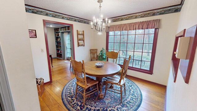 15047 E Peace Rd, Nevada, MO 64772 - dining space with a chandelier, plenty of natural light, light wood-style floors, and a textured ceiling