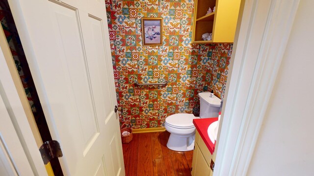 15047 E Peace Rd, Nevada, MO 64772 - bathroom with vanity, wood finished floors, toilet, and wallpapered walls