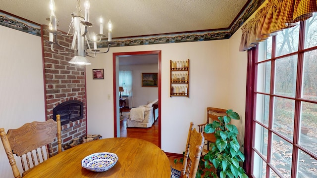 dining room with a fireplace, a textured ceiling, hardwood / wood-style flooring, and plenty of natural light