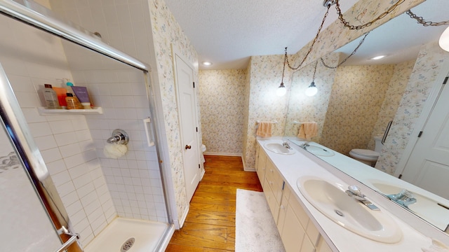 15047 E Peace Rd, Nevada, MO 64772 - bathroom with toilet, hardwood / wood-style floors, wallpapered walls, a stall shower, and double vanity