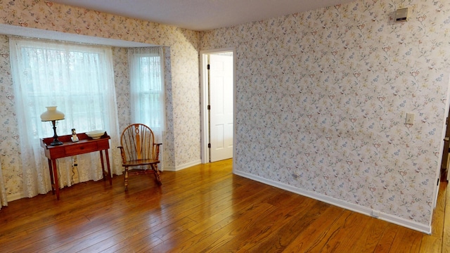 15047 E Peace Rd, Nevada, MO 64772 - spare room featuring hardwood / wood-style floors, wallpapered walls, and baseboards