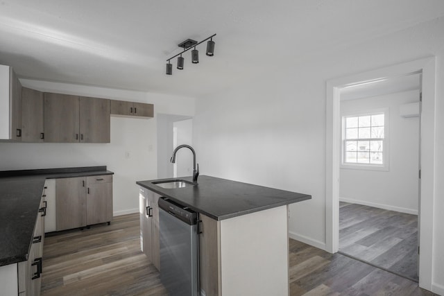 kitchen with dishwasher, sink, dark hardwood / wood-style floors, an island with sink, and track lighting