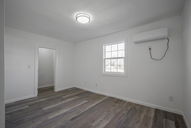 empty room with a wall mounted air conditioner and dark hardwood / wood-style flooring