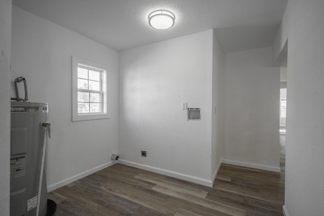 clothes washing area featuring water heater, hookup for a washing machine, dark hardwood / wood-style floors, and hookup for an electric dryer