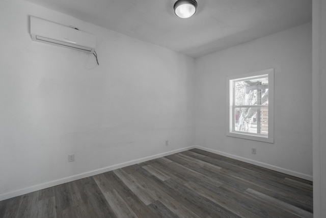 empty room featuring an AC wall unit and dark wood-type flooring